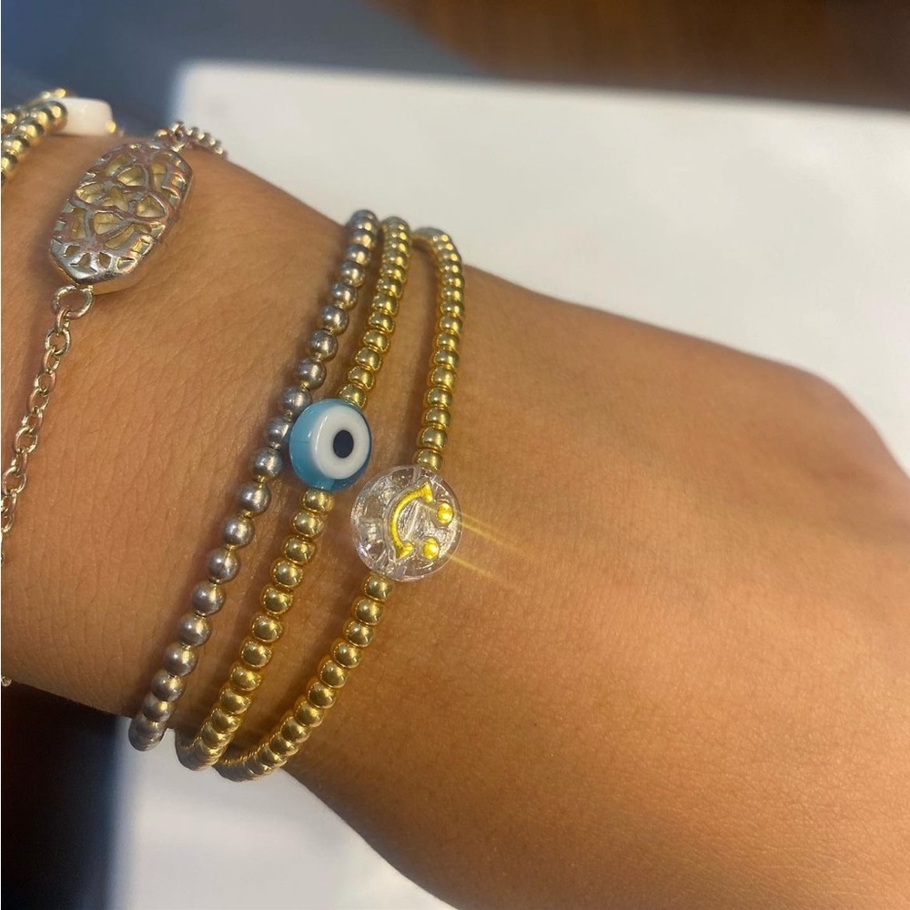 Gold evil eye and gold smiley face bracelet set.